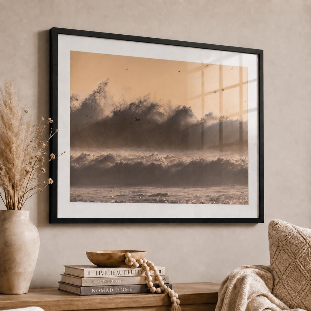 May include: A framed landscape wall art print featuring a monochromatic sepia-toned ocean scene with crashing waves and birds in flight against a soft light sky, displayed in a thin black frame with a white mat border.