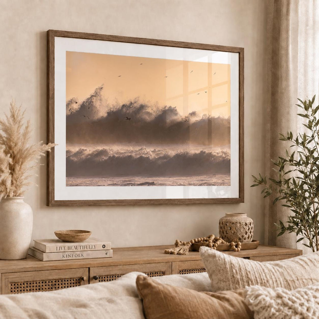 Crashing ocean wave photography displayed in an Oak Vintage Flair frame with a white mat and glossy acrylic glazing, showing a clear window reflection in a warm neutral room.