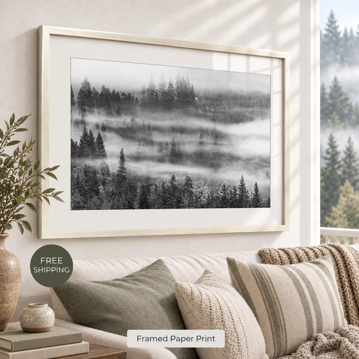 Misty evergreen forest photograph in black and white, with a white mat and pale Vintage Silver frame, displayed above a neutral sofa. Room mockup for the Vintage Silver finish.