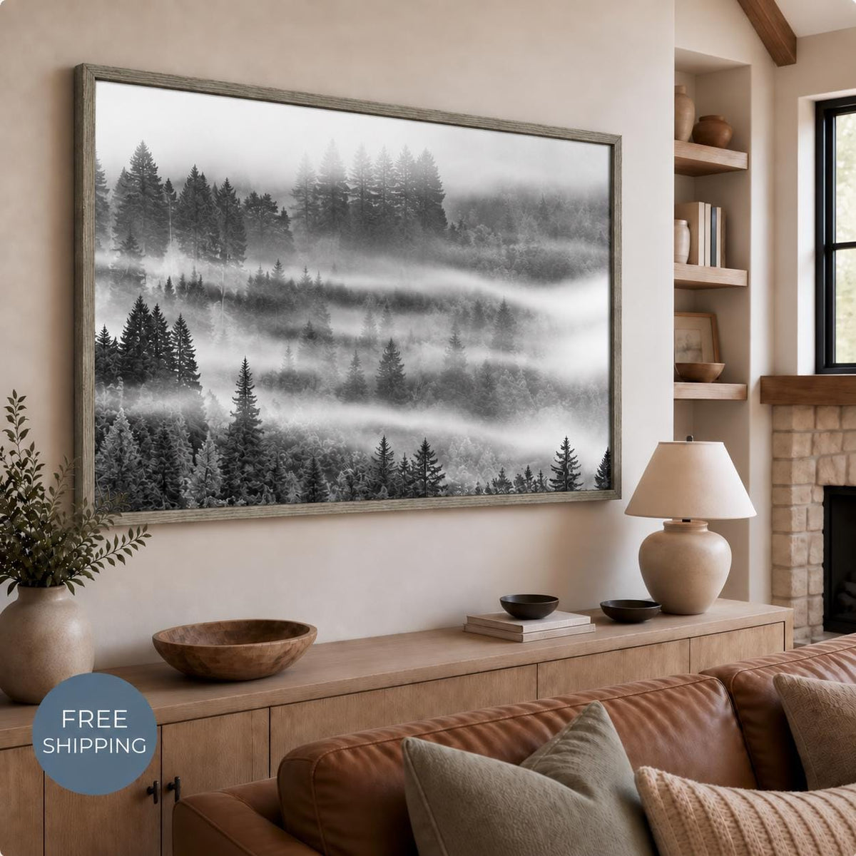 Black and white forest photograph in an Oak Vintage Flair floating frame above a wooden console. Dark evergreen trees emerge through pale bands of fog. A Free Shipping badge appears at lower left.