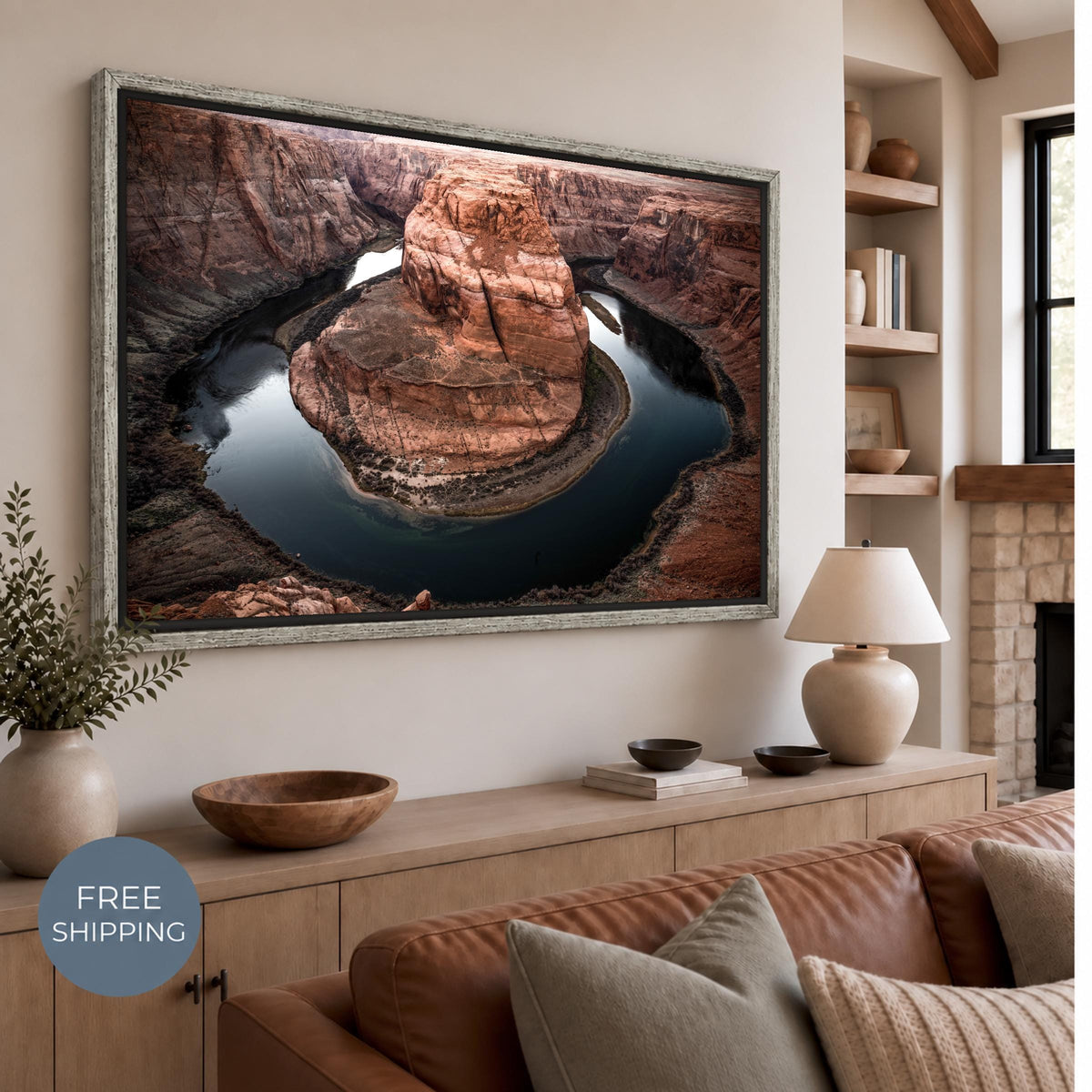 Horseshoe Bend canvas with a Vintage Silver floating frame in a distressed pale silver-gray finish. A narrow dark gap surrounds the canvas above a wooden sideboard and brown leather sofa. Free Shipping badge at lower left.